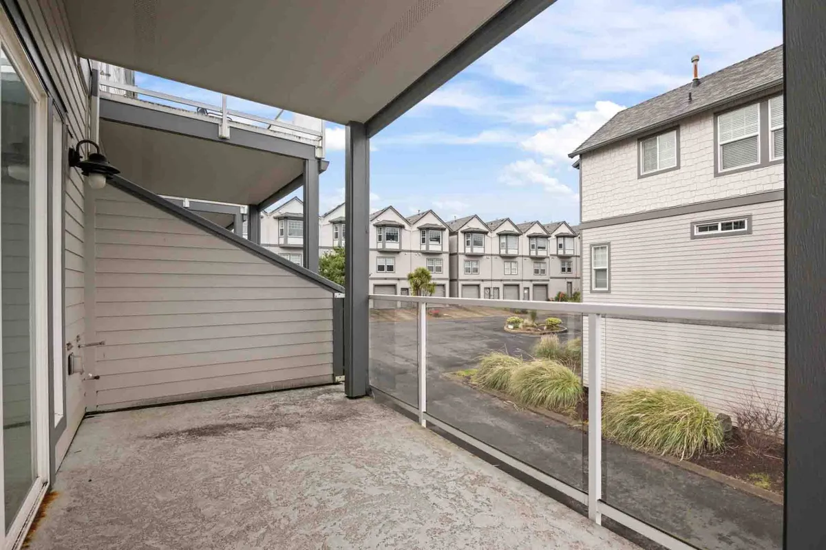 A serene balcony scene with a view of surrounding buildings and landscaped areas, inviting families to enjoy the outdoors right from their condo. The space offers a peaceful spot to relax, watch sunrises, or unwind after a day of adventure.